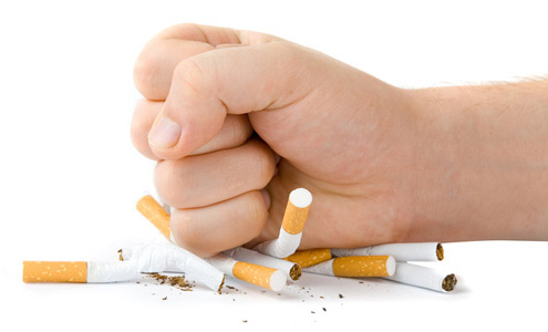 A hand crushing cigarettes